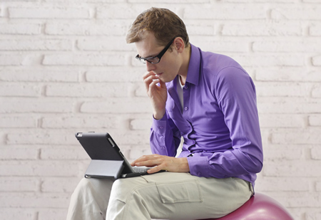 Photo of man hunched over laptop